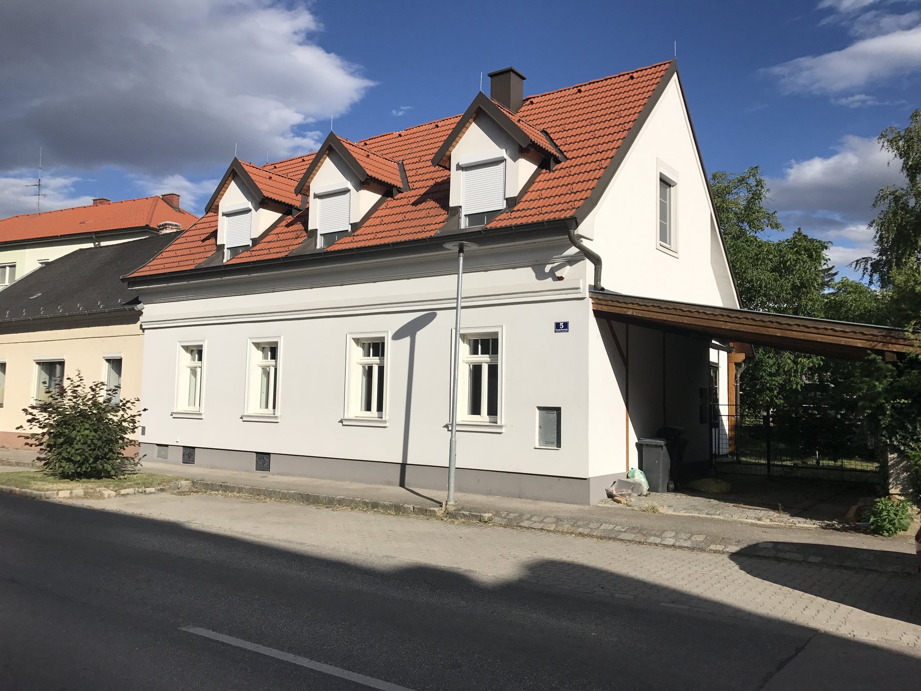Revitalisiertes Bestandsgebäude mit rotem Dach